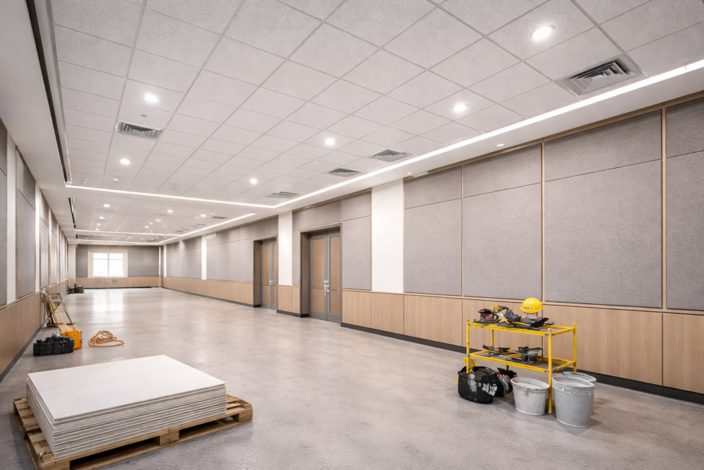 Acoustic ceiling tiles and wall panel systems installed in large commercial interior space.